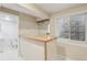 Basement wet bar with light wood countertop, wine glass rack and tile flooring at 4314 Nepal St, Denver, CO 80249