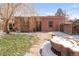 Brick garage and yard featuring stone walkway, snow and water feature at 3328 Bryant St, Denver, CO 80211