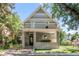 Inviting home facade featuring a covered front porch, patterned shingles, and lush trees for added shade at 3328 Bryant St, Denver, CO 80211