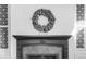 Traditional fireplace features an intricate mantle with a leaf wreath and decorative wallpaper at 3328 Bryant St, Denver, CO 80211