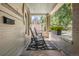 Inviting front porch with rocking chairs and stone flooring, perfect for relaxing outdoors at 3328 Bryant St, Denver, CO 80211