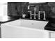 Close-up of a farmhouse-style sink with a chrome faucet and dark countertops at 3328 Bryant St, Denver, CO 80211