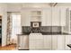 Well-lit kitchen featuring white cabinets, stainless steel appliances, and a farmhouse sink at 3328 Bryant St, Denver, CO 80211