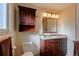 Bathroom with granite countertop, dark wood cabinets, and a large mirror at 7024 E Montana Pl, Denver, CO 80224