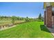 Expansive backyard featuring lush green grass and a charming fence overlooking a serene nature area at 7912 S Buchanan Way, Aurora, CO 80016