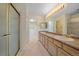 Bright bathroom with dual sinks, long vanity, glass shower, and a well-organized walk-in closet at 7912 S Buchanan Way, Aurora, CO 80016