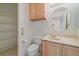 Powder room featuring a vanity, round mirror, light fixture, and a linen closet for storage at 7912 S Buchanan Way, Aurora, CO 80016