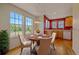 Cozy dining area with bright windows, a round table set for four, and wood floors at 7912 S Buchanan Way, Aurora, CO 80016