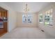 This light-filled dining room features neutral walls, carpet, and large windows, perfect for entertaining at 7912 S Buchanan Way, Aurora, CO 80016