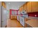Bright kitchen with wood cabinets, stainless steel appliances, and hardwood floors offers ample cooking space at 7912 S Buchanan Way, Aurora, CO 80016