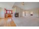 Living room with hardwood floors, a cozy fireplace, and an open view to the kitchen at 7912 S Buchanan Way, Aurora, CO 80016