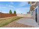 A cozy backyard with neutral fencing, gravel, and a concrete patio at 19047 Randolph Pl, Denver, CO 80249