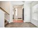 Bright foyer with tile flooring, carpeted staircase and a white front door at 19047 Randolph Pl, Denver, CO 80249