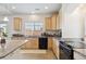 Bright kitchen with wood cabinets, granite countertops, and large windows at 19047 Randolph Pl, Denver, CO 80249