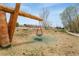 A single swing hangs suspended from a log in a community playground at 19047 Randolph Pl, Denver, CO 80249