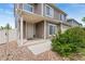 Inviting front porch with beige siding and rock ground cover and a front door with storm door at 19047 Randolph Pl, Denver, CO 80249
