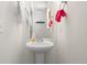 Compact powder room features a pedestal sink and neutral decor at 19047 Randolph Pl, Denver, CO 80249