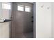Modern shower with gray tile and a built-in shelf featuring two small windows for natural light at 19047 Randolph Pl, Denver, CO 80249