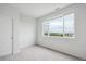 A bright, modern bedroom featuring a large window with treetop and city views at 487 Interlocken Blvd # 303, Broomfield, CO 80021