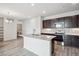 Modern kitchen boasts stainless steel appliances, an island with seating, dark cabinetry, and an adjacent laundry area at 487 Interlocken Blvd # 303, Broomfield, CO 80021