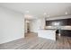 Modern kitchen view with stainless steel appliances, dark cabinetry, kitchen island, and adjacent laundry room at 487 Interlocken Blvd # 303, Broomfield, CO 80021
