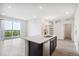 Bright and modern kitchen featuring an island with sink and barstool seating, stainless appliances, and exterior views at 487 Interlocken Blvd # 303, Broomfield, CO 80021