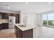 Modern kitchen featuring dark cabinetry, stainless steel appliances, a kitchen island and sliding glass door to the balcony at 487 Interlocken Blvd # 303, Broomfield, CO 80021
