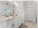 Modern bathroom with double sinks, quartz counters, large mirror, and a glass-enclosed shower at 8480 Arriba Dr, Littleton, CO 80125