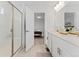 Bright bathroom featuring double sinks with white cabinets, a tile floor, and a glass shower at 8480 Arriba Dr, Littleton, CO 80125
