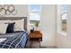 Well-lit bedroom featuring a window with mountain views and modern bedside table at 8480 Arriba Dr, Littleton, CO 80125