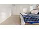 Bright bedroom features a bed with a blue patterned blanket, and bright white trim and walls at 8480 Arriba Dr, Littleton, CO 80125