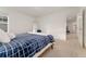 Well-lit bedroom featuring a bed with a patterned blue blanket and a view into the hallway at 8480 Arriba Dr, Littleton, CO 80125