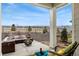 Inviting outdoor patio space with comfortable seating, a fire pit, and views of the surrounding landscape at 8480 Arriba Dr, Littleton, CO 80125