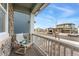 Cozy front porch features a comfortable chair, a decorative pillow and a white wooden railing at 8480 Arriba Dr, Littleton, CO 80125