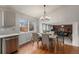 Bright dining area with hardwood floors, a table for four, and a view of the living room at 11455 River Run Pkwy, Commerce City, CO 80640