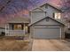 Two-story house with gray siding and attached garage at 11455 River Run Pkwy, Commerce City, CO 80640