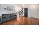 Living room with hardwood floors, gray sofa, and view of the staircase at 11455 River Run Pkwy, Commerce City, CO 80640