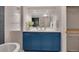Updated bathroom with blue cabinets, quartz countertop, and modern fixtures at 9400 Ridge Rd, Arvada, CO 80002