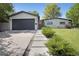 Inviting home exterior boasts a gray garage door, concrete path, and lush green bushes at 9400 Ridge Rd, Arvada, CO 80002