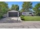 Charming home featuring a manicured lawn, gray garage door, and pathway leading to the front door at 9400 Ridge Rd, Arvada, CO 80002