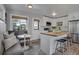Well-lit kitchen featuring white cabinets, stainless steel appliances, and a convenient breakfast bar at 9400 Ridge Rd, Arvada, CO 80002