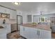 Open concept kitchen with stainless appliances, tile floors, an island, and a view into the bright living space at 9400 Ridge Rd, Arvada, CO 80002