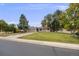 Inviting single-story home with a lush lawn, mature trees, and a paved driveway under a blue sky at 505 Everett St, Lakewood, CO 80226