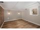 Finished basement with brick accent wall, new flooring, and recessed lighting throughout at 1050 N Clarkson St, Denver, CO 80218