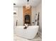 Bright bathroom featuring a sleek tub with a brick fireplace and a crystal chandelier at 1050 N Clarkson St, Denver, CO 80218