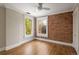 Brick-accented bedroom with hardwood floors, windows, and neutral paint at 1050 N Clarkson St, Denver, CO 80218