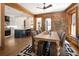 Inviting dining room featuring exposed brick, wood beams, and open layout to kitchen at 1050 N Clarkson St, Denver, CO 80218