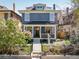 Two-story blue home with a cozy front porch and a landscaped front yard at 1050 N Clarkson St, Denver, CO 80218