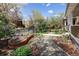 Pathway leading through the landscaped front yard with flower beds and mature trees at 1050 N Clarkson St, Denver, CO 80218