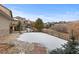 Stone path leading to a snowy backyard with wooden fence and serene greenery at 1039 Buffalo Ridge Way, Castle Pines, CO 80108